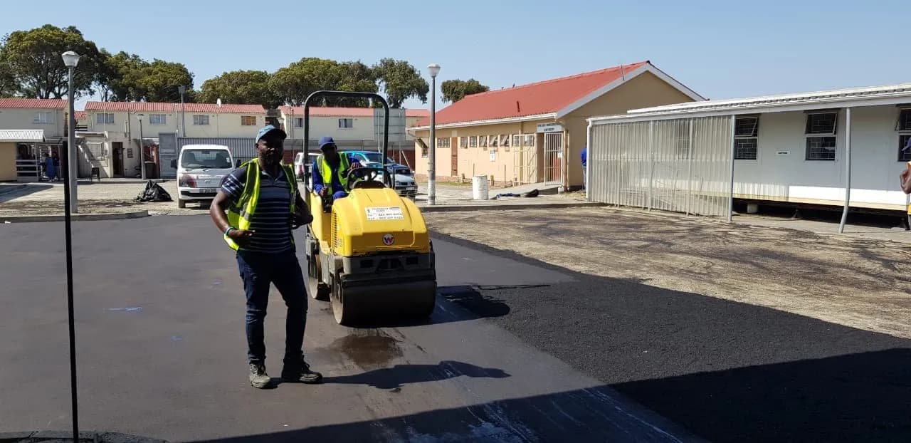 Operator with a compactor on newly surfaced asphalt