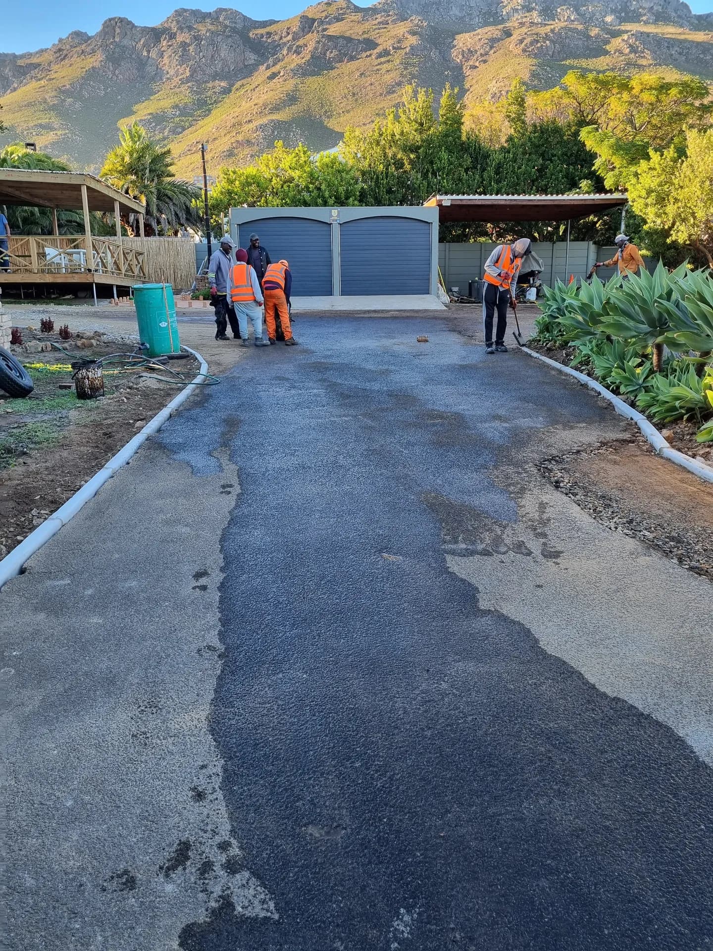 Driveway being surfaced between kerbed garden beds